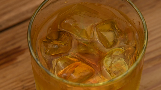 冰块落在酒吧柜台的威士忌杯中视频