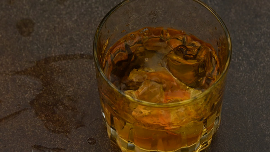冰块落在酒吧柜台的威士忌杯中视频