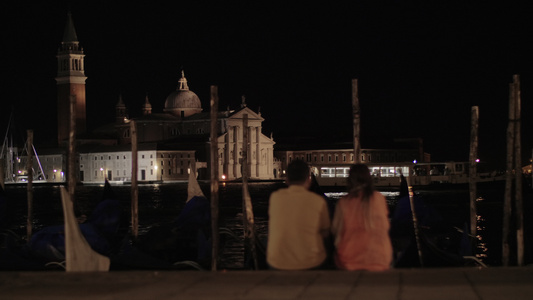 一对夫妇坐在堤岸上在晚上的风景前视频