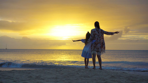 小女孩和快乐的母亲在海滩的日落时光下摇着月光10秒视频