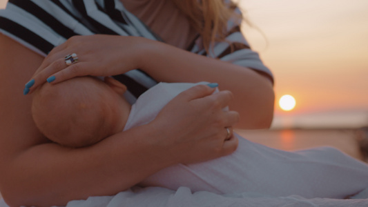 日落时户外哺乳婴儿的母亲视频