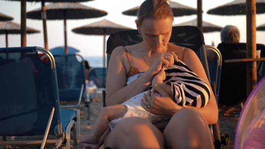 妇女在海滩上哺乳婴儿视频