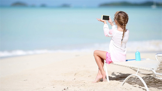 小女孩用照相机拍摄录像或照片坐在日晒上视频