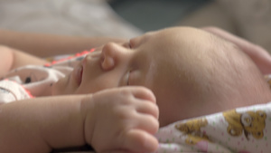 在大腿上摇摇着睡着的宝宝13秒视频