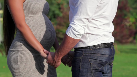 男人握着他的怀孕妻子的手视频