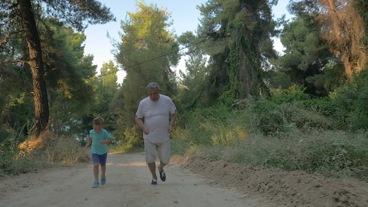 祖父和孙子在森林里慢跑视频