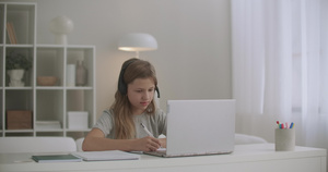 女童正在网上学习通过互联网与教师沟通使用耳机和笔记本电脑13秒视频