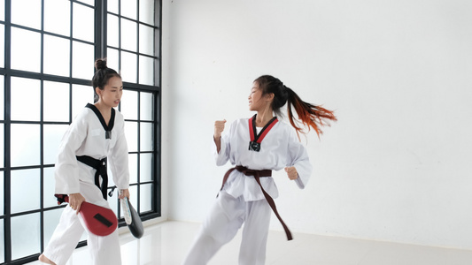 女教练教技术用一些工具给学生使用Taekwondo视频
