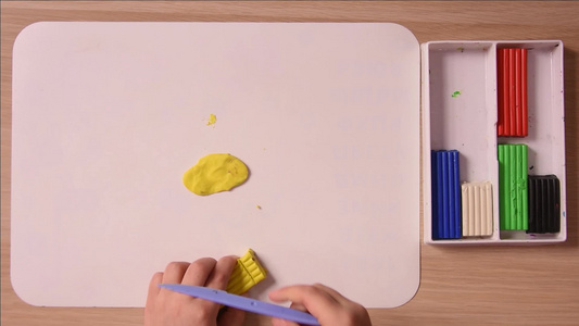 孩子切掉一块黄色的塑胶做手工艺缝合顶端视图视频
