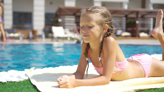 美丽的小女孩在户外游泳池附近玩得开心视频