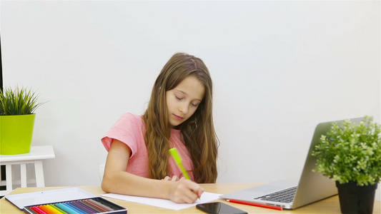 重度女学生与笔记本和教科书一起坐在桌边做功课视频