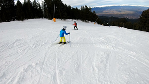 小男孩喜欢学习滑雪沿着他父亲的脚跟滑坡慢动作59秒视频