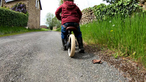 慢动作小男孩骑平衡的自行车后仰视着27秒视频