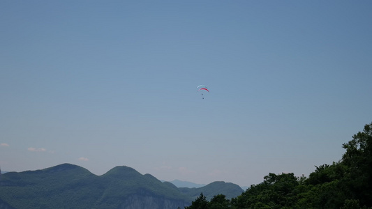 大山峡谷蓝天白云云朵滑翔伞飞翔4K实拍视频