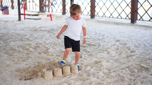 男孩摧毁沙滩城堡海滩童年暑假家庭度假视频