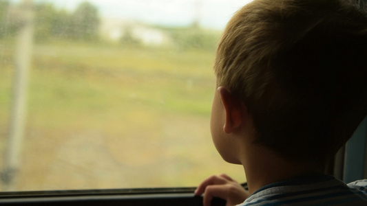 男孩向着火车车窗外看视频