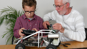 爷爷和小男孩在修理无线电控制的模型车24秒视频