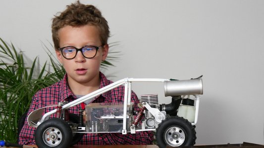 小男孩在家修理一辆无线电控制车的模型小男孩视频