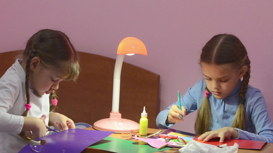 两个孩子做手工艺一个剪刀切成剪刀彩色纸板第二个记分为视频