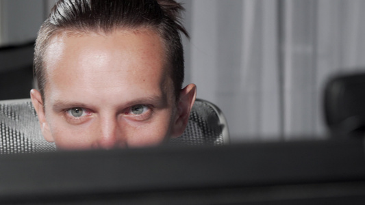 一只雄性眼睛在看电脑监视器时拍到的滑轮镜头视频