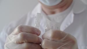 手拿着塑料注射安瓿的医务人员关闭男性医生手准备安瓿20秒视频