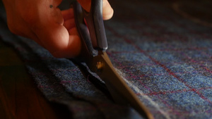 缝纫时切割花呢在工作室的桌子上用剪刀剪裁织物剪裁过程8秒视频