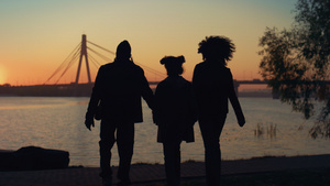 在美丽的夕阳下相爱的家庭剪影一起走到河岸28秒视频
