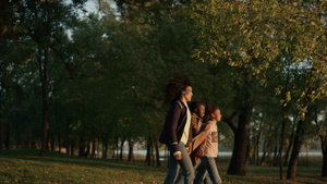 在傍晚金色的阳光下一家人手牵着手在秋天的公园散步17秒视频