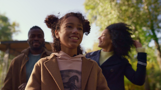 肖像快乐的女儿与微笑的父母一起散步公园视频