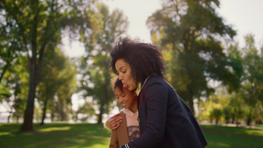 快乐妈妈拿着智能手机和可爱的女儿在公园里自拍视频