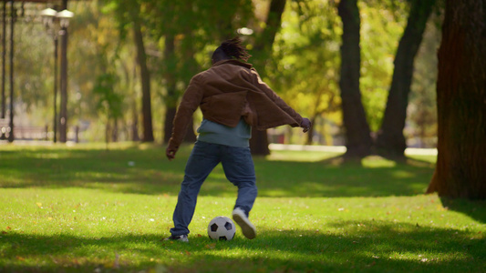 男子在温暖的春日踢足球公园视频