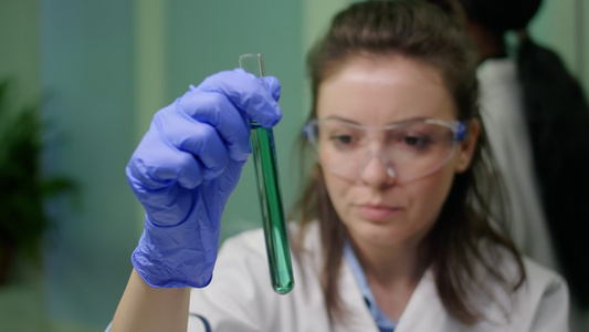 持有带有dna液体的测试管的女性化学研究员视频