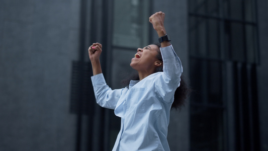 幸福的女人独自在办公楼庆祝成功视频