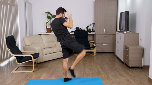 体育男子踢和拳打在客厅里视频