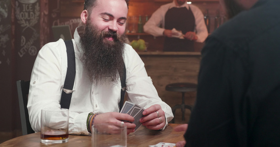 长胡子长胡子的人笑着和朋友玩牌视频