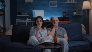 晚上在电视上看电影吃爆米花的一对夫妇22秒视频