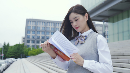 青年女学生走下楼梯看书视频