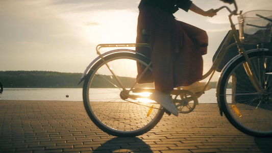 夕阳下海边逆光骑着自行车的人视频