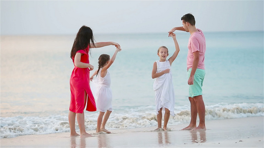 在海滩上暑假期间父母和两个可爱的孩子玩得很开心视频