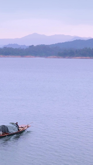 清晨宁静的湖面上驾驶着渔船外出扑鱼的渔民原生态30秒视频