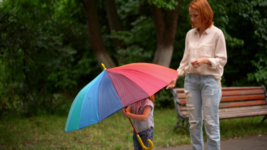 在彩色雨伞下快乐的母亲和女儿视频