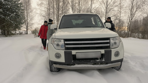 父母亲和女儿在寒雪的冬季森林中坐上汽车21秒视频