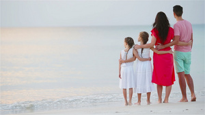 海滩上快乐的美丽家庭日落时父母和孩子的背影23秒视频