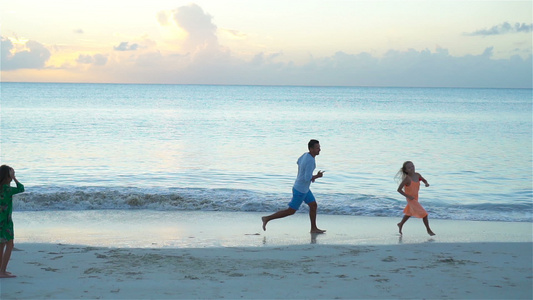 日落时在海滩上享受家庭乐趣慢动作视频