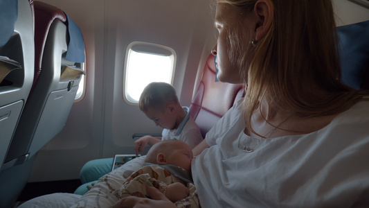 母亲与儿子和女婴乘飞机飞行视频