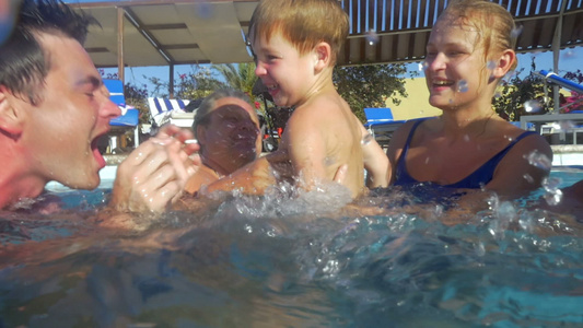 男孩和他的家人在游泳池里玩得开心视频