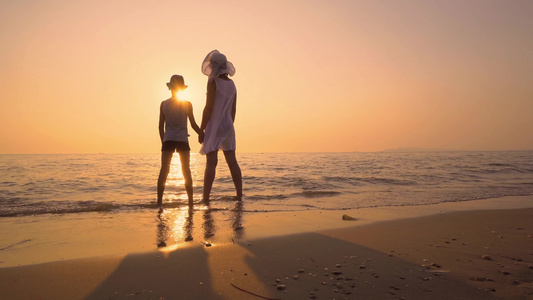幸福的家庭母亲和儿子在日落海滩玩游戏拥抱并交流情感视频