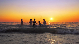 家庭成员在夏日海滩的日落时分欢快跳跃电影慢动作30秒视频