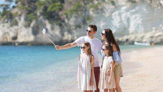 年轻美丽的家庭在海滩上拍自拍肖像视频