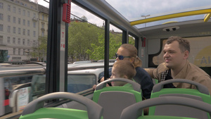 乘双层巴士在城里旅行的三口人家庭34秒视频